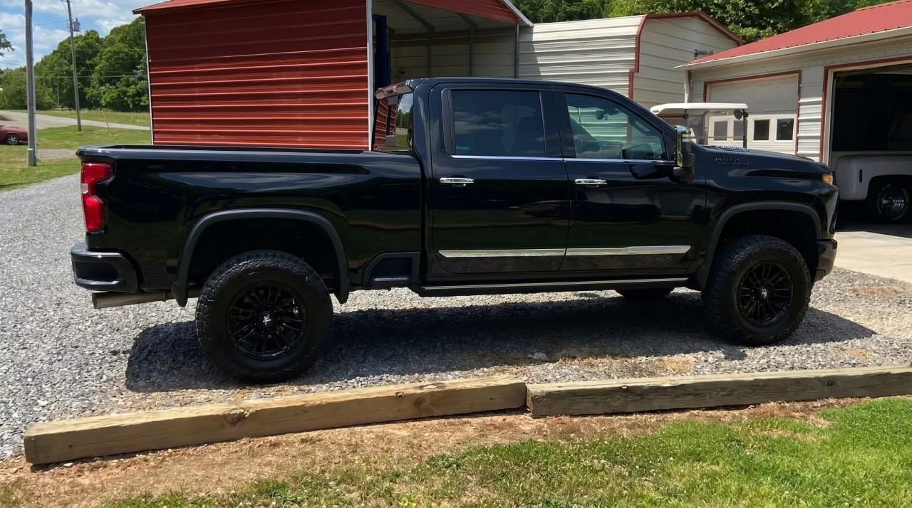 A black pickup parked on a gravel drive